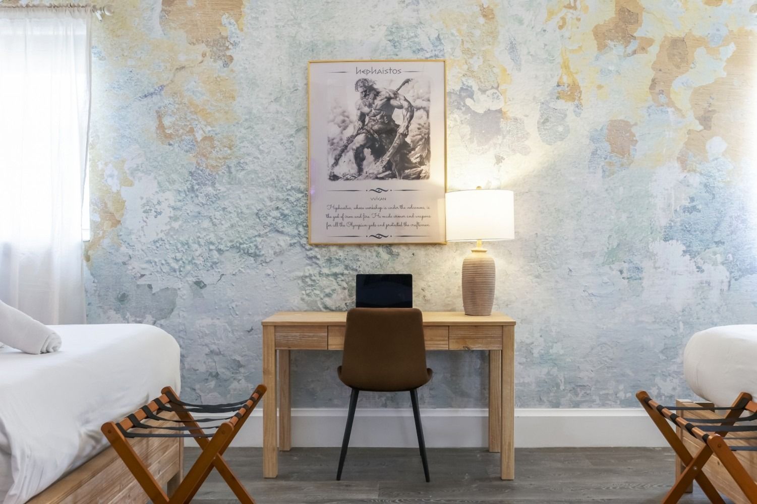 Bright bedroom with desk, lamp, chair, twin beds, and a blue floral wall mural