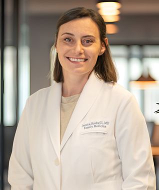 Smiling medical professional in a white coat standing indoors