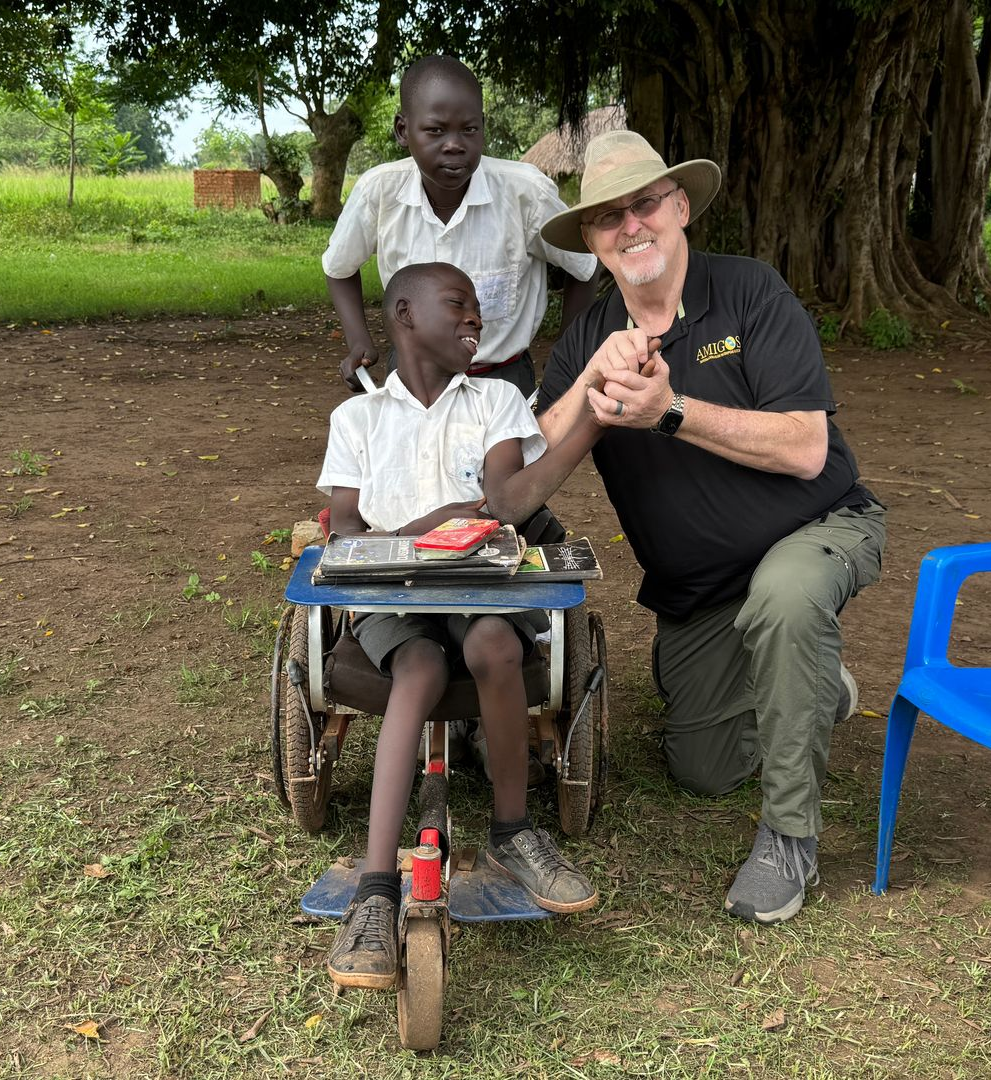 CEO, Michael Ryer holding hands with Balaam in wheelchair. Benjamin, his brother stands behind them.