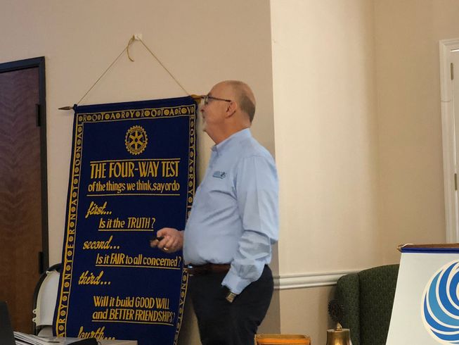 Man beside a blue banner with text