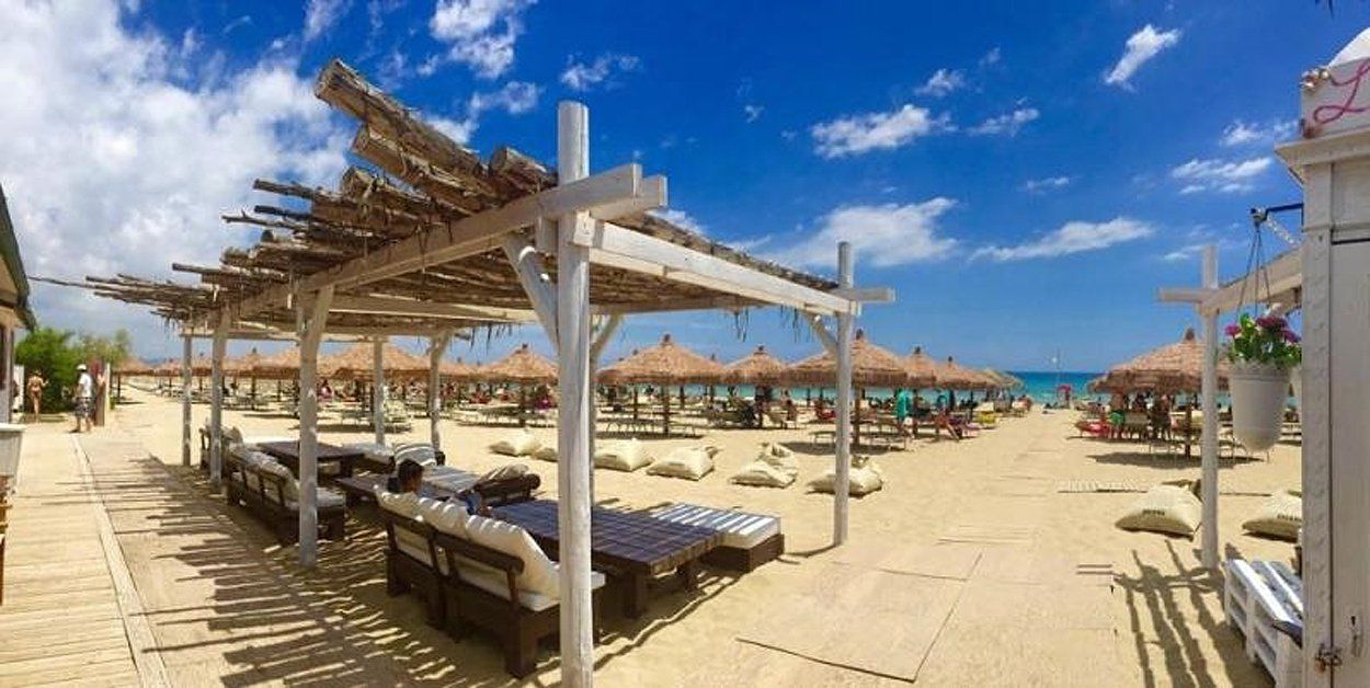 spiaggia con tavolini e copertura