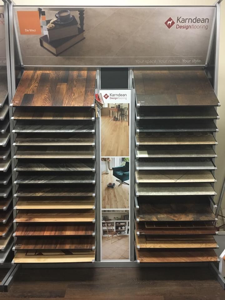 Flooring display showcasing wood samples. Brown, tan, and gray tones. Kerndean Design brand.