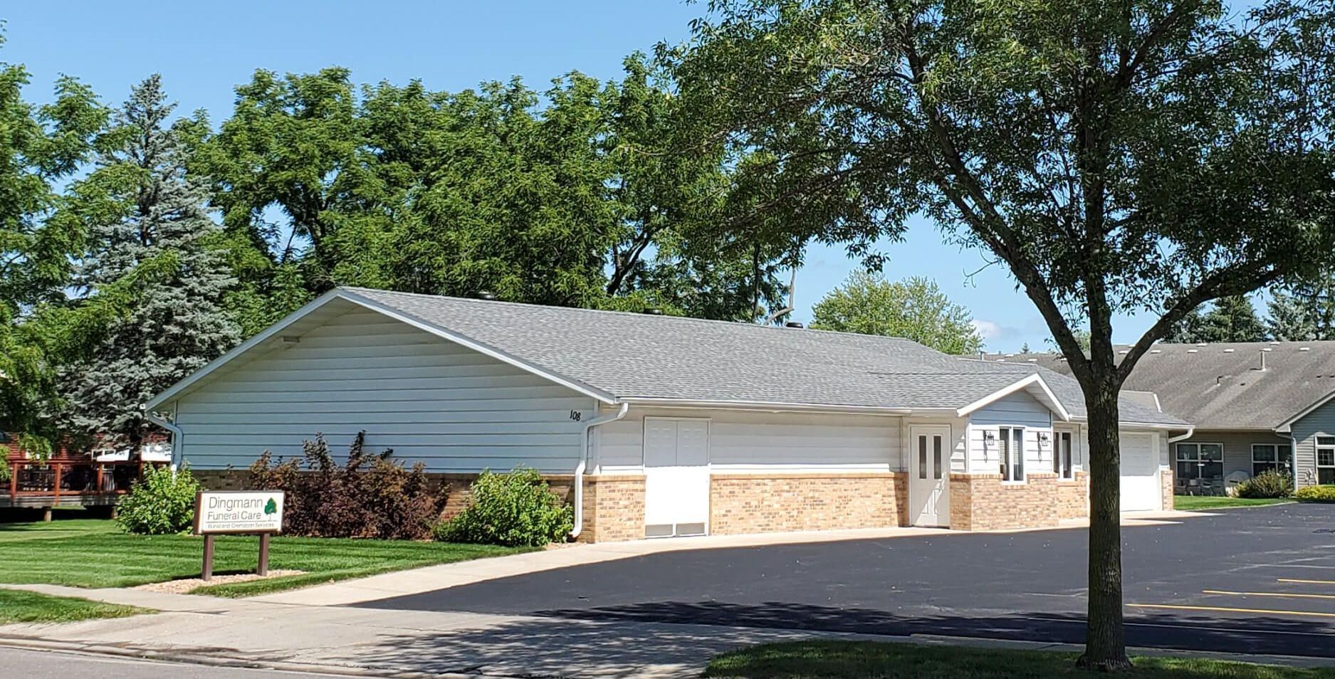 A white house with a tree in front of it