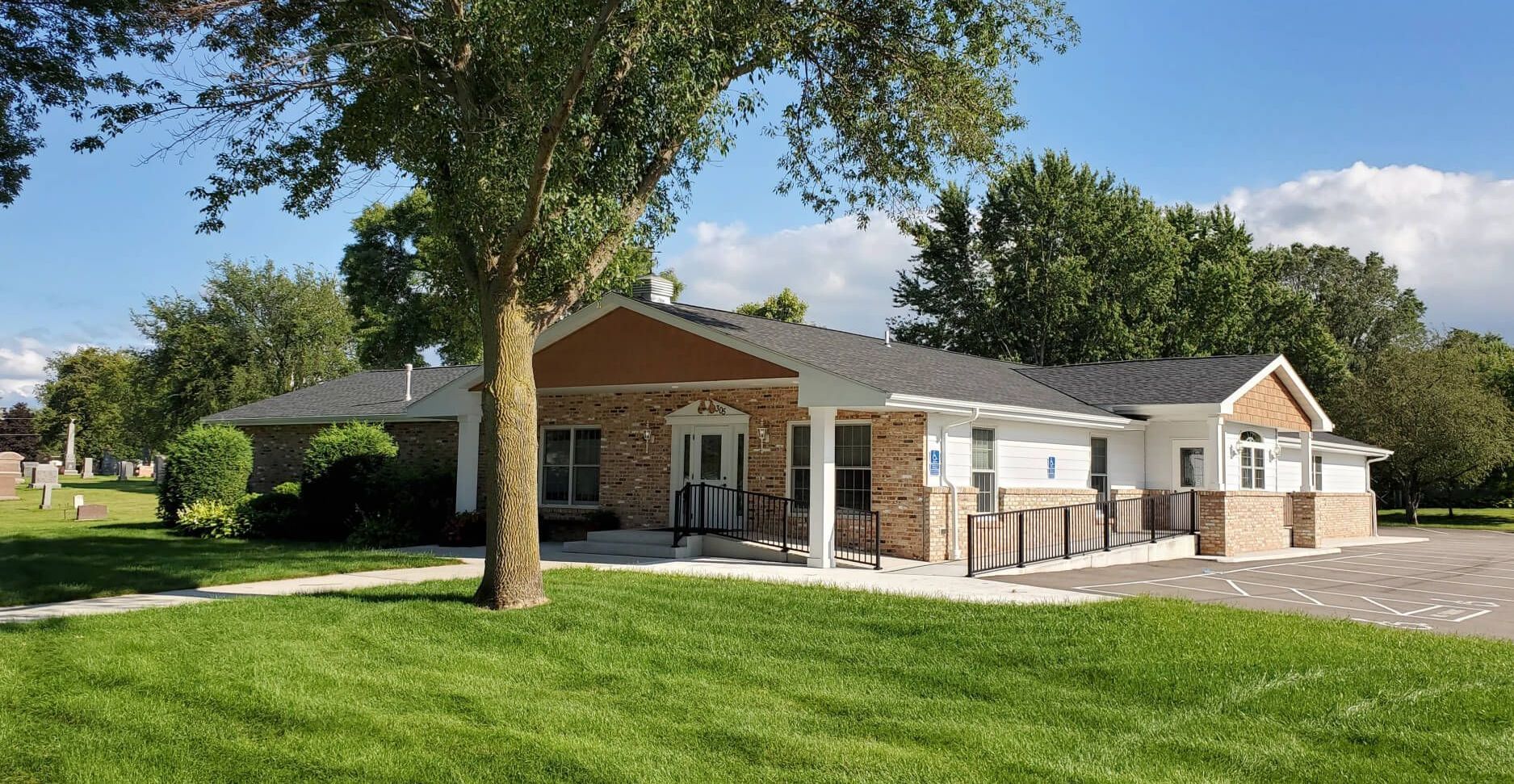 A house with a tree in front of it on a sunny day