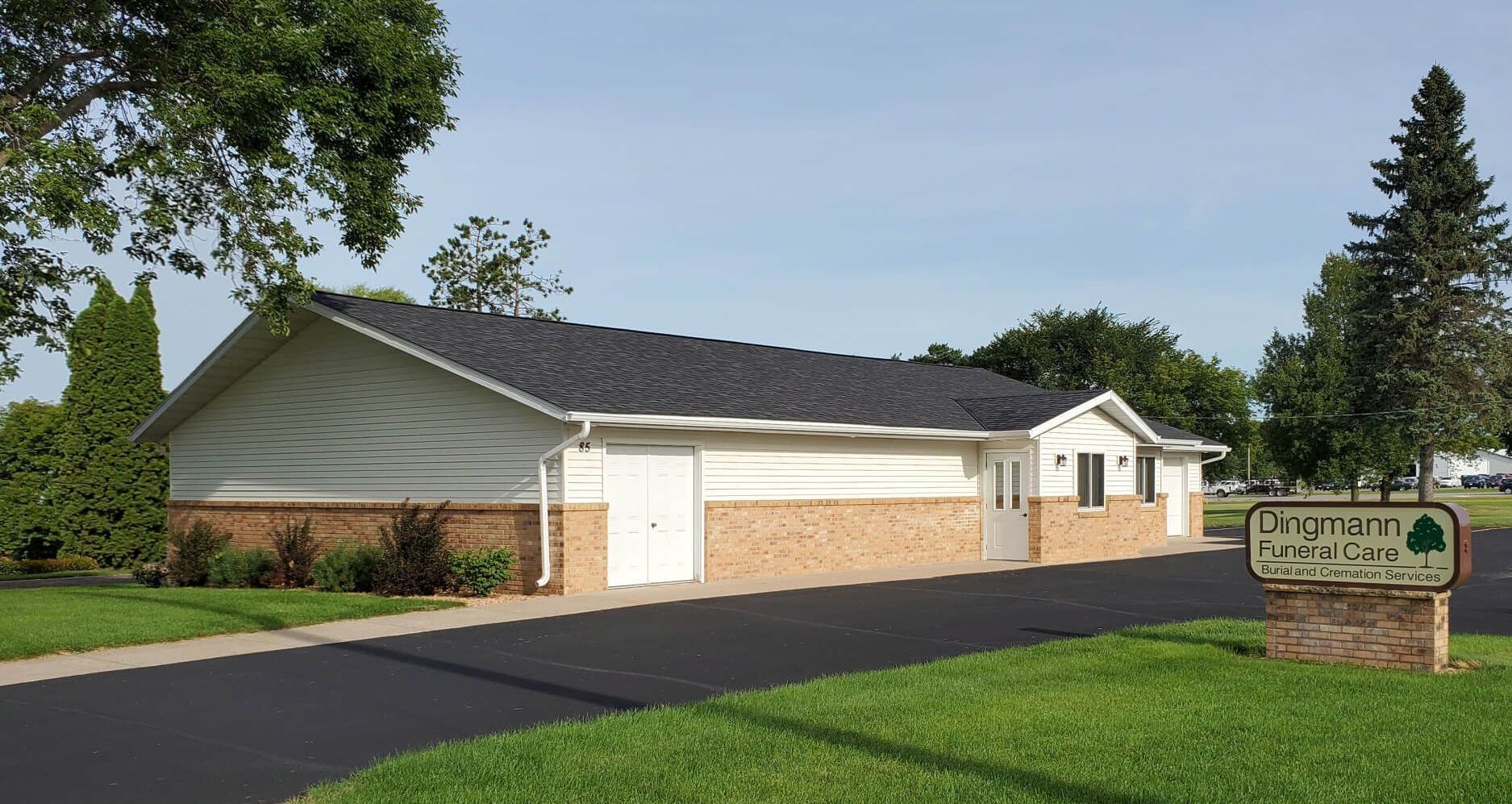 A house with a tree in front of it on a sunny day