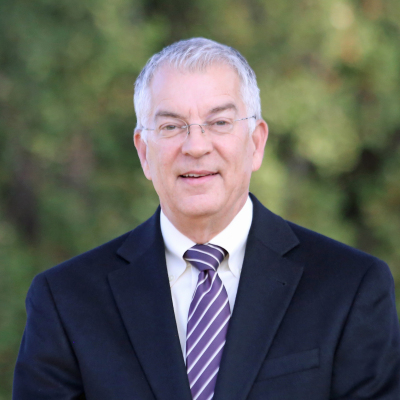 A woman wearing hoop earrings and a white shirt is smiling for the camera.