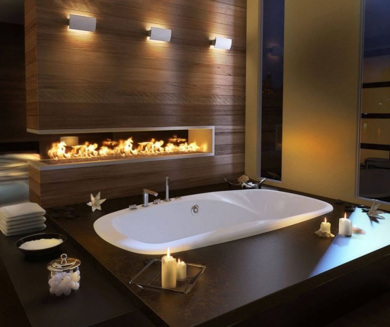 A bathtub in a bathroom with candles and a fireplace