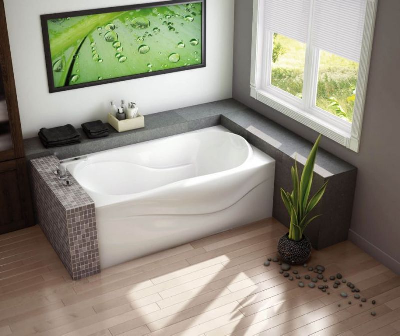 A bathtub in a bathroom with a picture on the wall above it