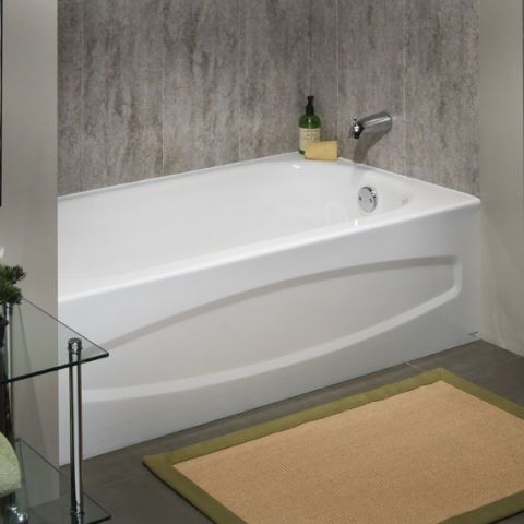 A white bathtub in a bathroom next to a rug