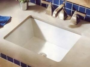 A bathroom sink with a blue tile wall behind it