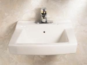 A white bathroom sink with a chrome faucet on a tiled wall.