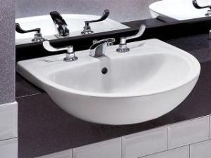 A white sink is sitting on a counter next to a mirror.