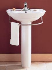 A white pedestal sink with a towel rack attached to it.