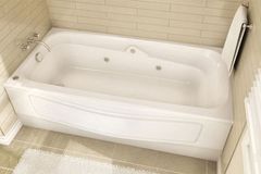 A white bathtub is sitting in a bathroom next to a towel.