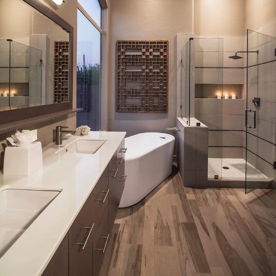A bathroom with two sinks a tub and a shower