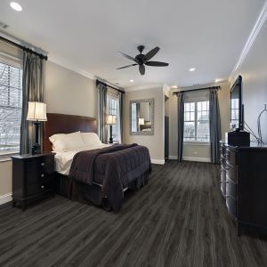 A bedroom with a bed , dresser , nightstand , and ceiling fan.