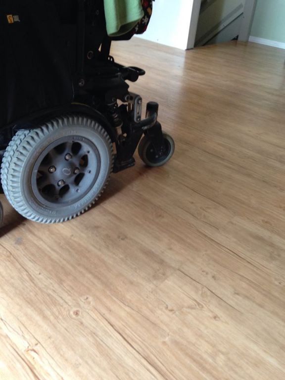A wheelchair is sitting on a wooden floor