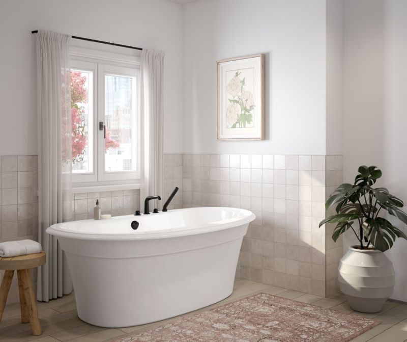 A bathroom with a tub , stool , plant and window.