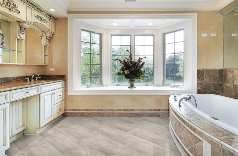 A bathroom with a tub , sink , and window.