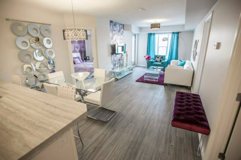 A living room with a dining table and chairs and a purple bench.