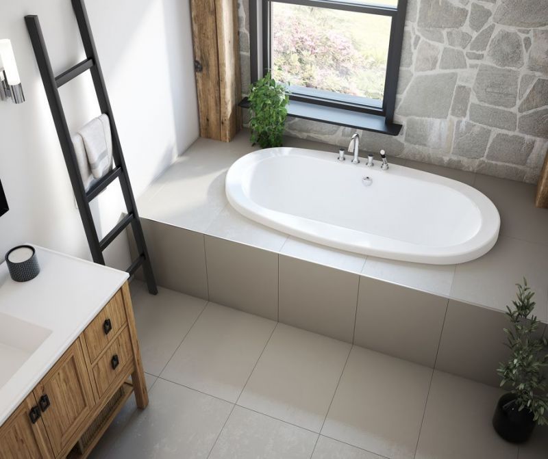 A bathroom with a bathtub , sink and window