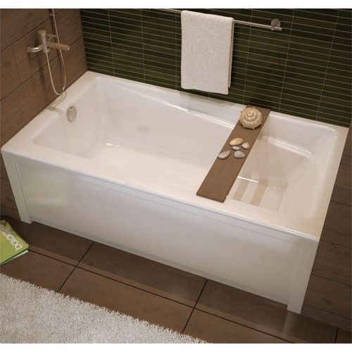 A bathtub with a wooden tray on top of it in a bathroom.