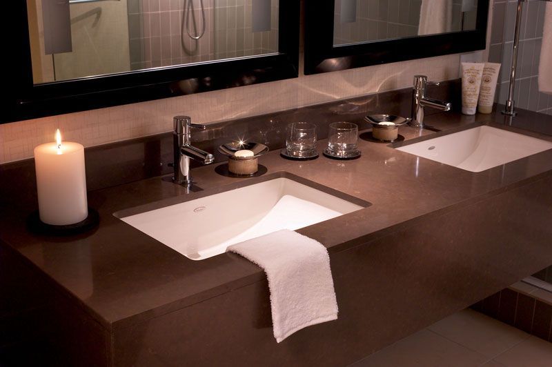 A bathroom with two sinks and a candle on the counter