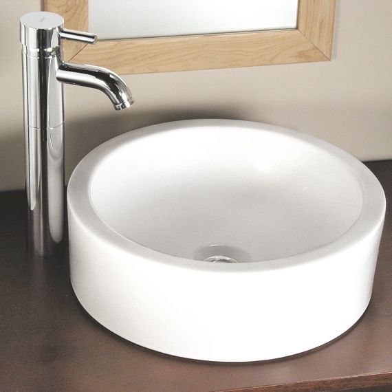 A round white sink with a chrome faucet next to a mirror
