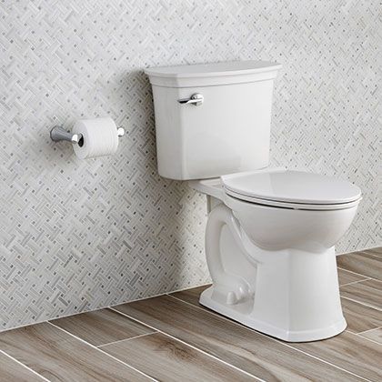 A white toilet is sitting in a bathroom next to a wall.