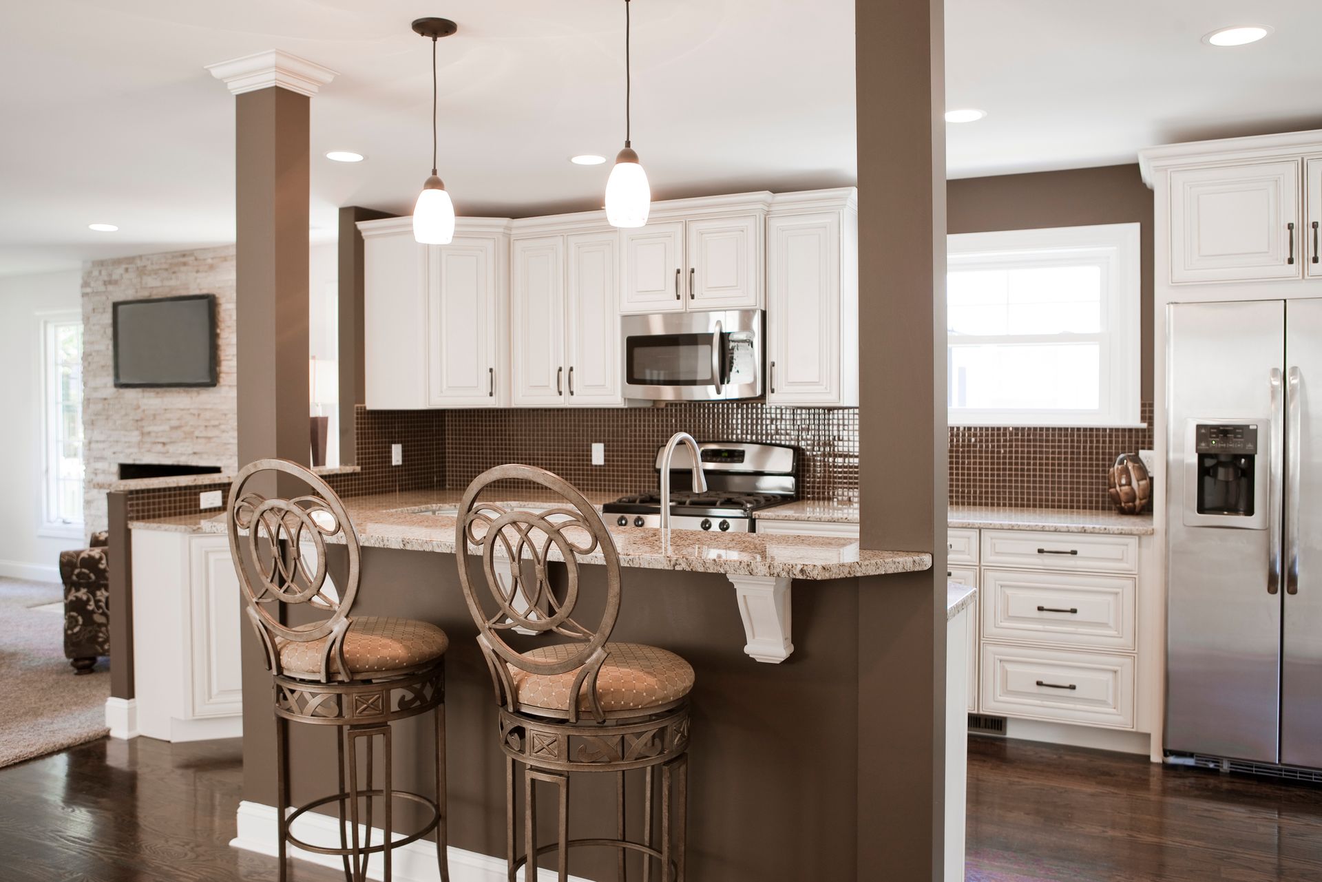 Modern kitchen with white cabinets, granite island, and pendants. Modern kitchen with white cabinets, granite island, and pendants.