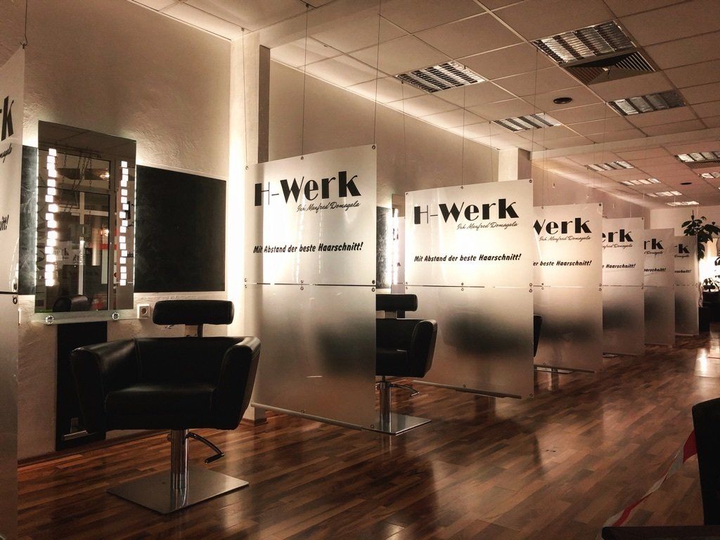 Eine Stuhlreihe in einem Salon mit der Aufschrift „f-werk“