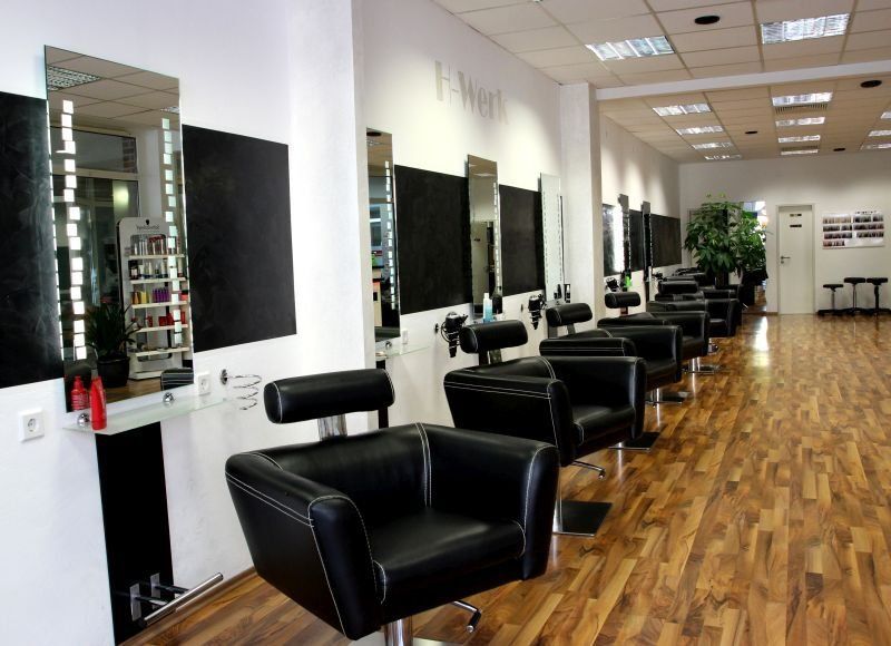 Eine Reihe schwarzer Stühle in einem Friseursalon