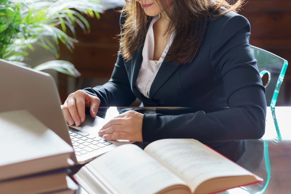 A Woman in a Suit Works Focused on a Laptop
