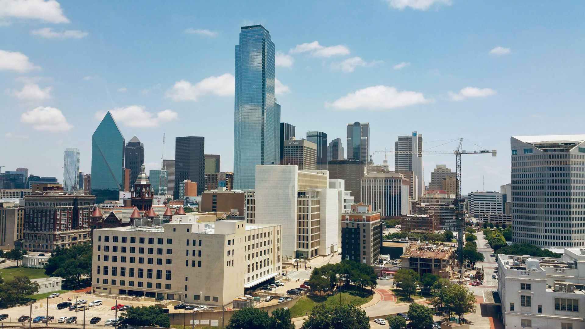 Skyline of a downtown city with tall glass skyscrapers under a clear blue sky