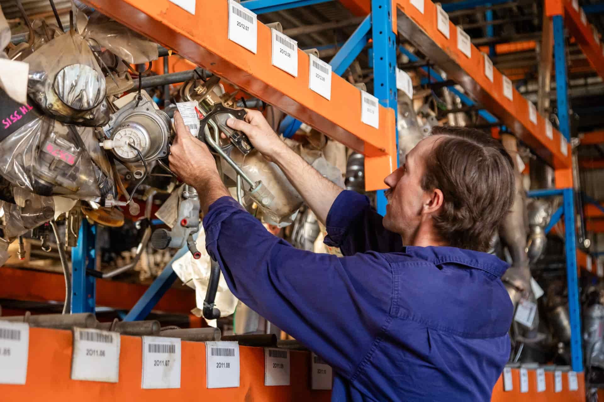 Man Examines Automotive Parts — Scott's 4WD Parts Plus In Dubbo, NSW
