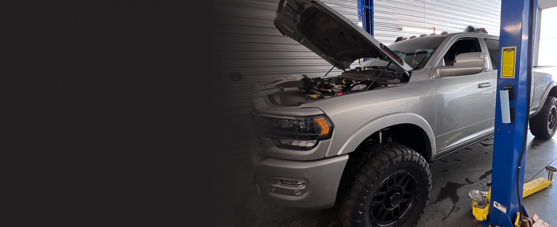 Two vehicles with open hoods in a garage setting, one is a Jeep, the other a truck. | Mike's Garage CC