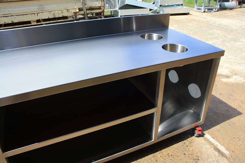 A stainless steel counter with two sinks on it