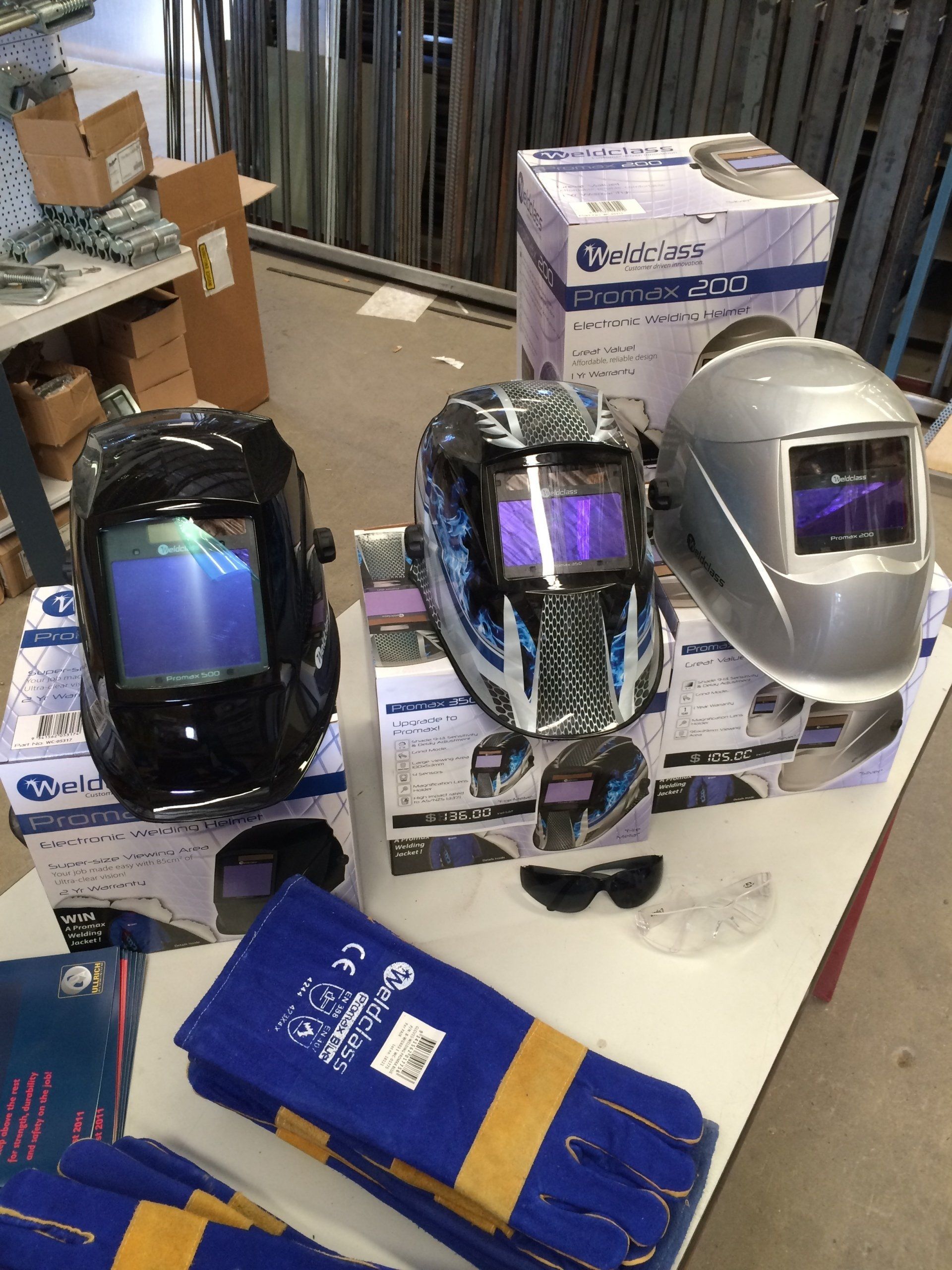 a table with welding helmets and gloves on it