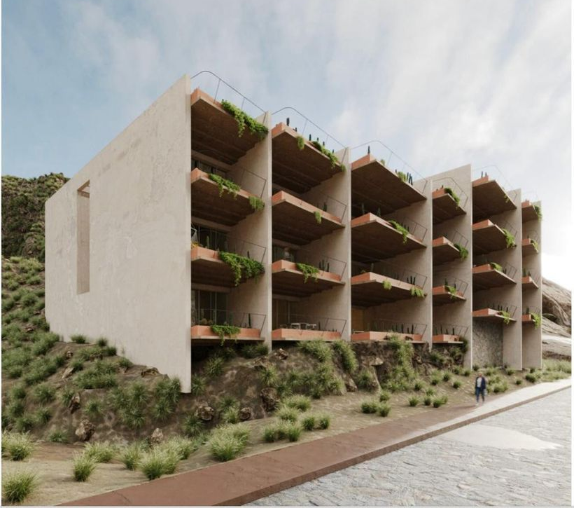 Modern building with multiple balconies on a hillside. Person walking on sidewalk.