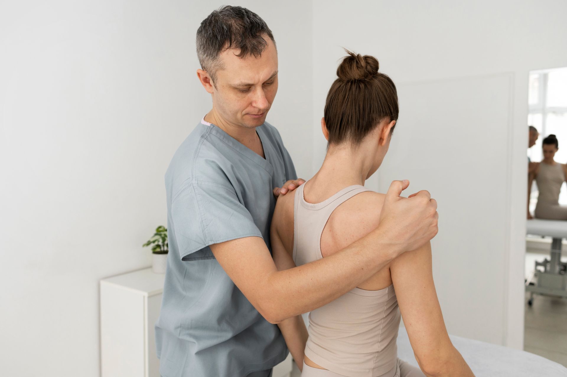 A man is giving a woman a massage in a hospital.