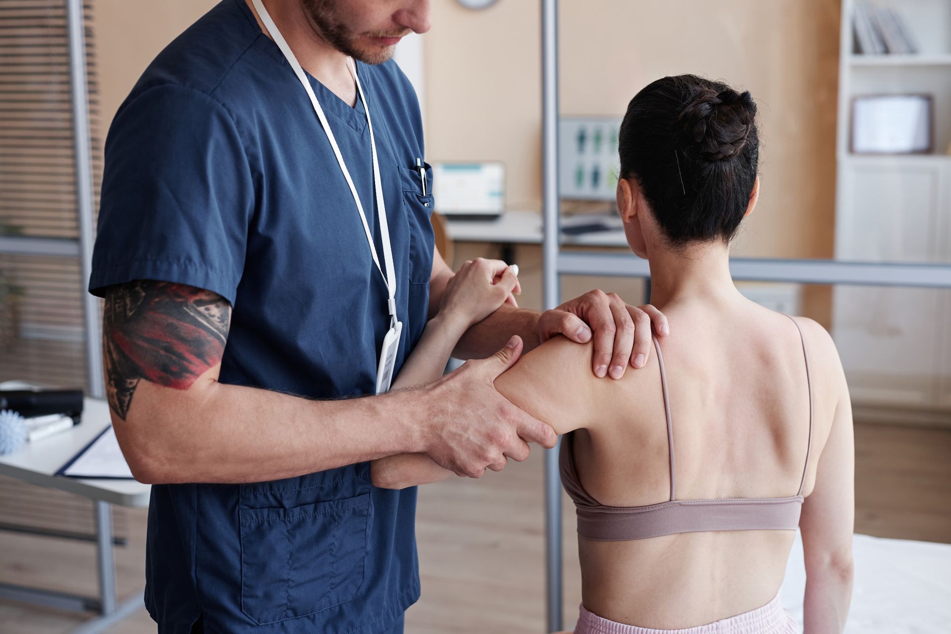 A doctor is examining a patient 's shoulder in a hospital.