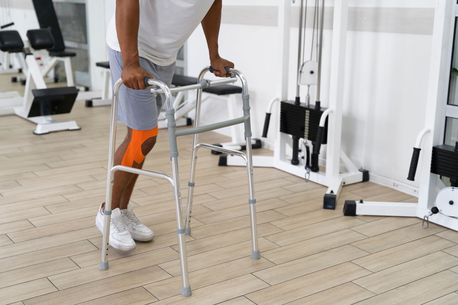 A man is using a walker in a gym.