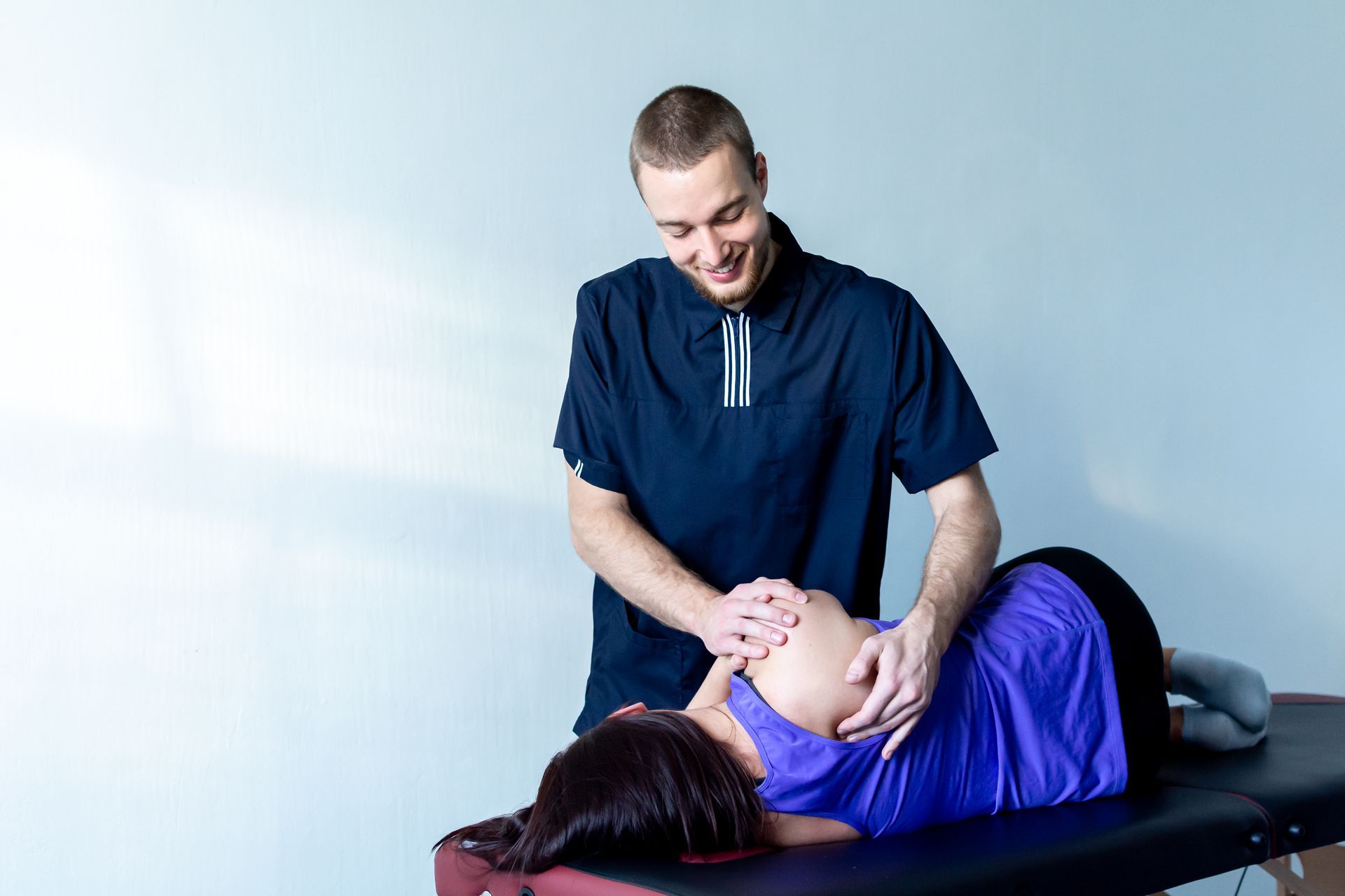 A man is giving a pregnant woman a massage on a table.