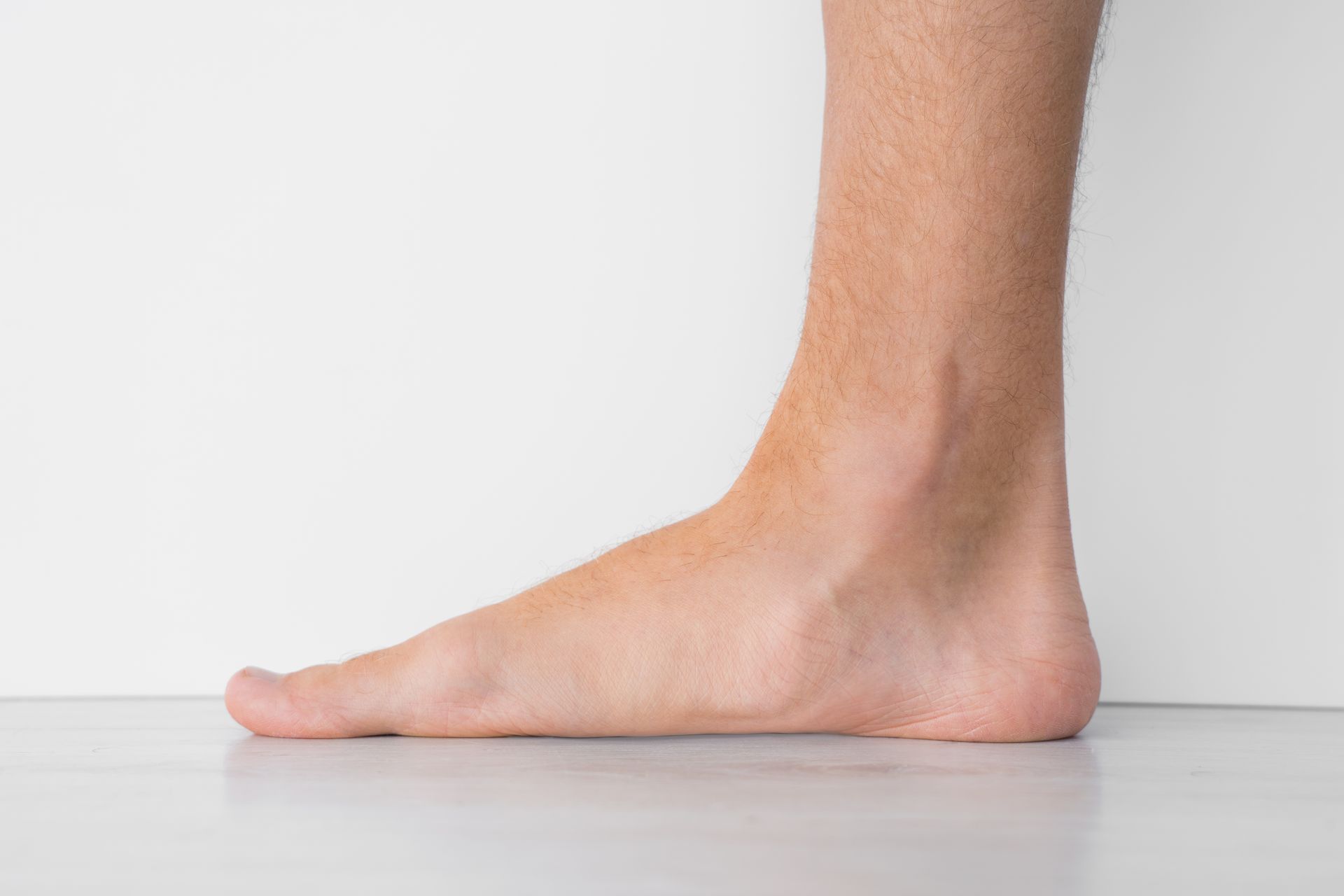 A close up of a person 's foot against a white wall.