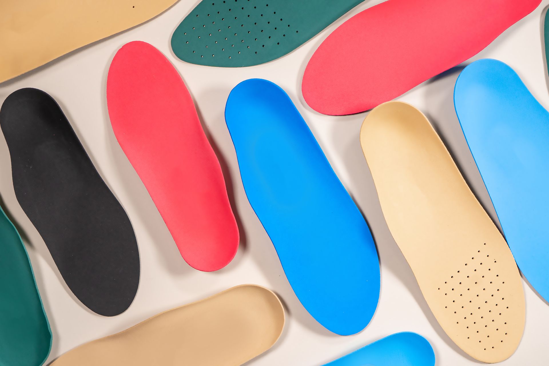 A bunch of different colored insoles on a white surface