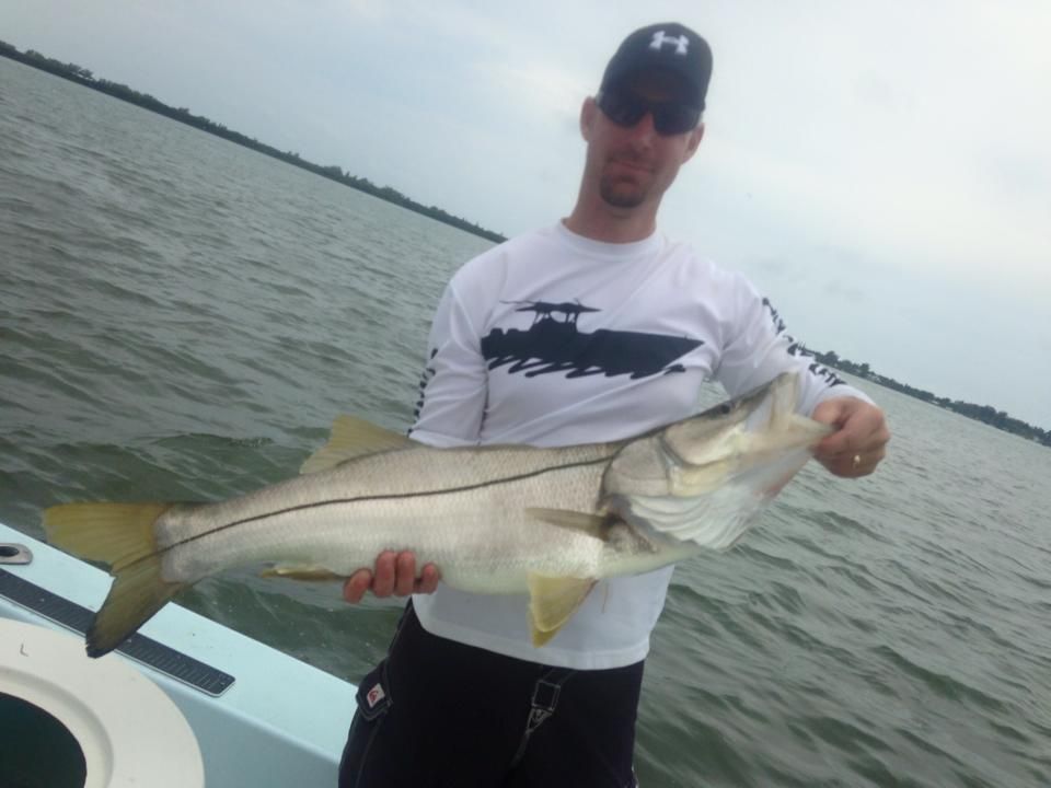 A man on a boat holding a large fish