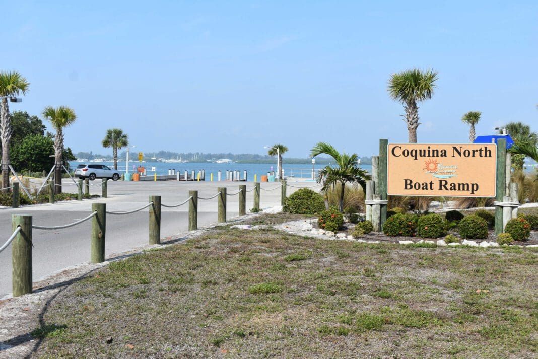 A sign for coquina north boat ramp is in front of a beach.