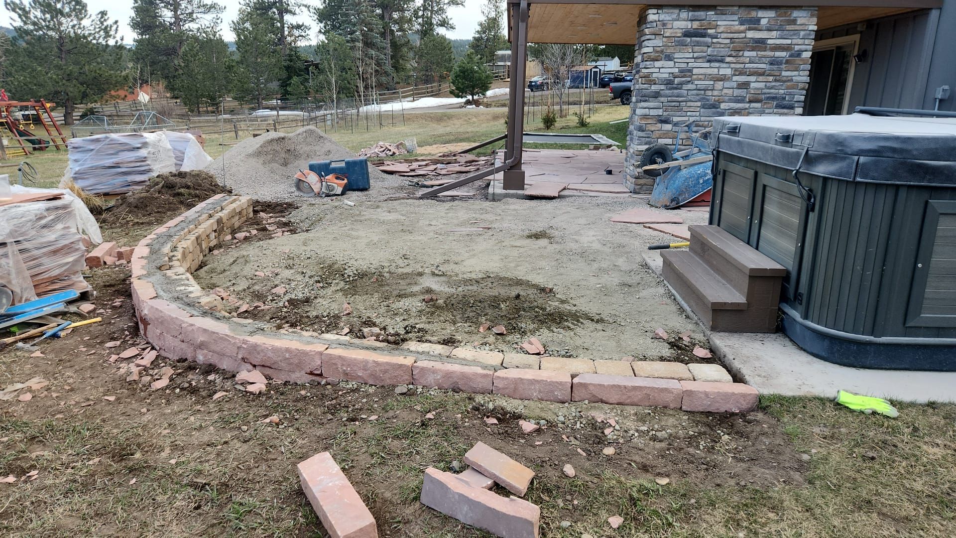 A hot tub is being built in the backyard of a house.
