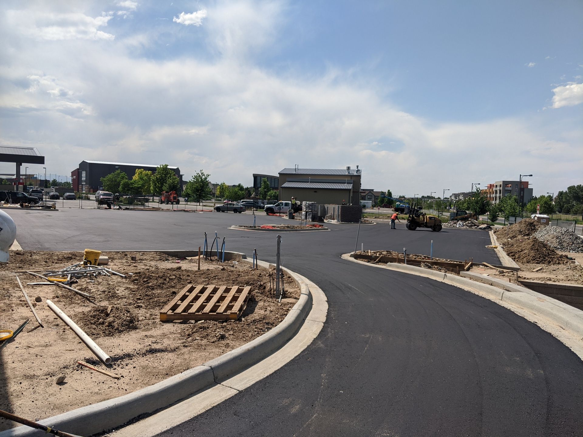 A construction site with a lot of dirt and a building in the background