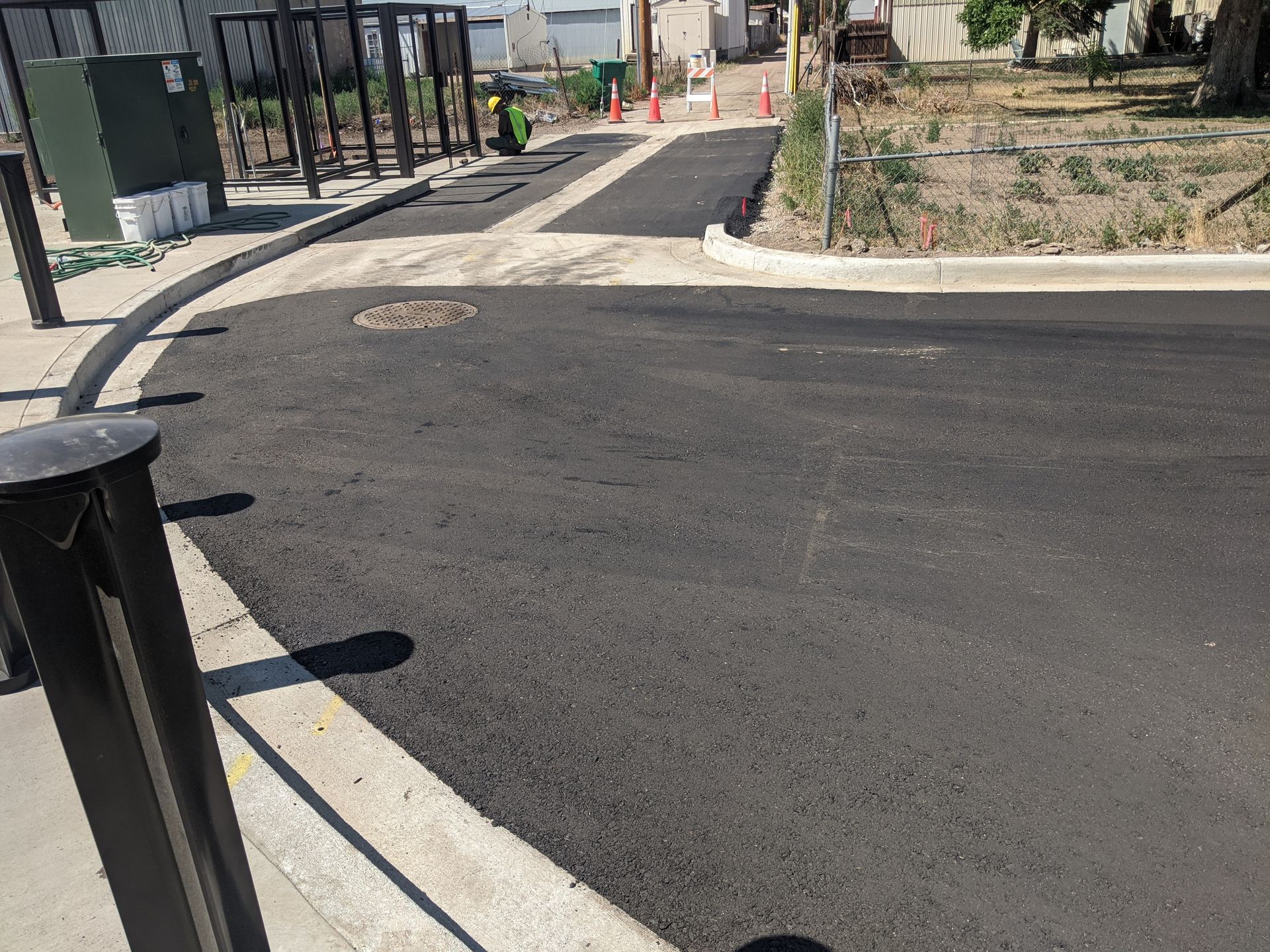 A black asphalt road with a fence in the background